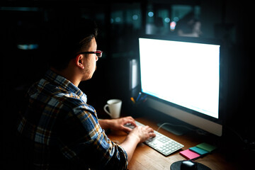 Leinwandbilder - Putting his skills to work. Shot of a young male designer working on his computer late at night.