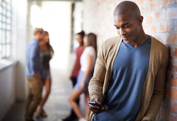 Wall Mural - Making plans. Shot of a young man sending a text message.