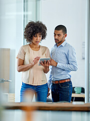 Poster - Office connections. Shot of two office colleagues having a discussion over a digital tablet.