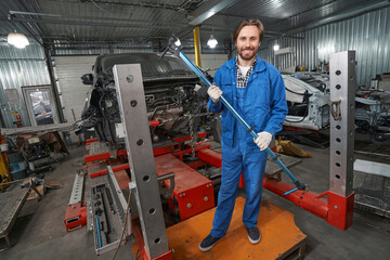 Wall Mural - Smiling man holding special tool for auto repair