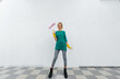 © Andrii - A young girl is engaged in repairs and smiles with a pink roller in her hands against a white wall in a new apartment. Renovation of the interior and a new apartment.
