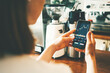 © Alex from the Rock - Woman in coffee shop with mobile investing app in her hand, close-up