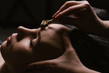 Soft light image of a woman receiving forehead massage in a beauty salon