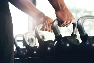 Poster - Hold on to the things that make you strong. Cropped shot of an unrecognizable sportsman lifting kettle bells in a gym.