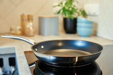 Steel Frying Pan In The Kitchen On Electric Induction Hob, Modern Kitchen Appliance