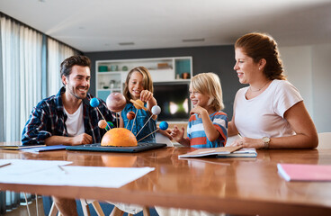 Poster - Shes taking us on a journey through the galaxy. Shot of a beautiful young family working together on a science project at home.