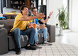 © lordn - Male Friends Having Fun, Watching a Game On the TV. Cheering for their sports team