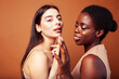 © iordani - young pretty asian, afro woman posing cheerful together on brown background, lifestyle diverse nationality people concept