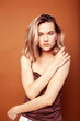 © iordani - young pretty girl with blond hair posing cheerful on brown background, lifestyle people concept