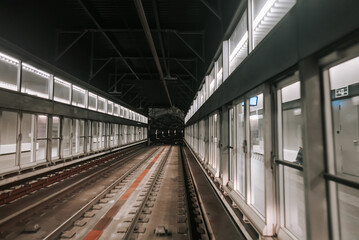 Wall Mural - Front cabin view of moving subway carriage between airport terminals. Riding driverless metro train in Barcelona. Advanced transportation system, underground tunnel.