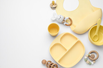 Composition with baby accessories and bib on white background, top view. Space for text