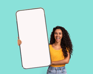 Poster - Beautiful Millennial Woman Demonstrating Big Smartphone With Blank White Screen At Camera