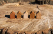 © Jarama - wooden house models on tree stump in the outdoors. concept image for wood as a renewable and sustainable building material for modular timber architecture.