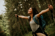 Young Female Backpacker Woman Enjoying Green Beautiful Forest Around Her