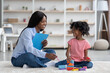 © Prostock-studio - Excited african american kid and child psychotherapist playing with bricks