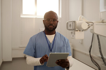Aufkleber - Young serious African American male clinician in uniform with tablet looking at camera while consulting patients online