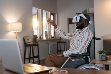 Aufkleber - African American man with disability preparing virtual presentation while sitting in wheelchair by his workplace in living room at home