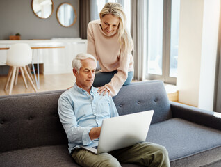 Poster - Getting more out of retirement by staying current. Shot of a mature couple using a laptop on the sofa at home.