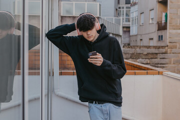 Poster - young teenager with headphones and mobile phone or smartphone in the city