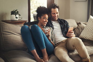 lock the door, leave the world outside. shot of a happy young couple using a digital tablet while re