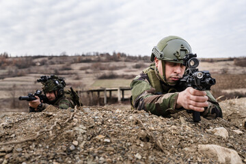 Two men soldiers holding position in the battle war zone aiming rifles dogs of war professional mercenaries or volunteers special forces on a mission attacking or defending enemy copy space