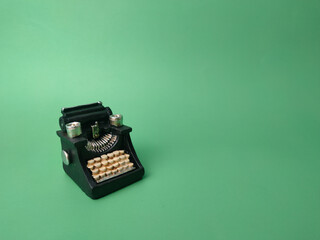 Vintage black typewriter on the green background, copy space for your text