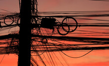 Huge And Several Electric And Communication Wires And Cords Hang On Pole With Disorganized And Confused In Colorful Evening Sky Background