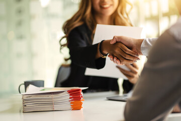 Asian business woman shaking hands after a successful job interview at office.