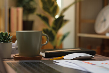 Poster - laptop with paperwork on wood table in living room at home.work at home