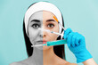 © _KUBE_ - Results before and after cosmetic procedures. Portrait of a woman holding three syringes in hands near the face. Light blue background. The concept of plastic surgery and rejuvenations injections