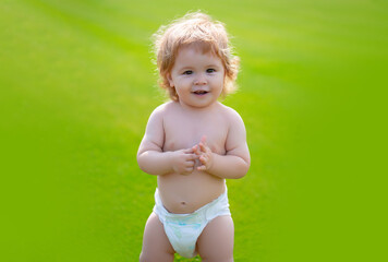 Sticker - Cute baby in diaper on green grass in summertime. Funny little kid on nature. Happy Childhood. Baby and summer sunny weather. Funny little child closeup portrait. Kids emotion, happy smiling face.