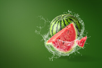 Wall Mural - Water splashing on Sliced of watermelon on green background