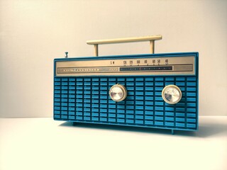 old blue transistor radio on white table, vintage old style filtered photo