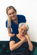 © PoppyPix - Vertical portrait of two caucasian woman - elderly lady and young millennial nurse - looking at camera and smiling. High quality photo