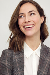 Wall Mural - Close-up portrait of beautiful young businesswoman looking happy and confident to the left. Big smile on her face, looking beautiful and cheerful standing isolated on white background.