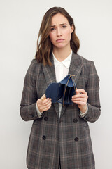 Young sad business woman over white background holding an empty wallet. Isolated on white. Concept: No money. 