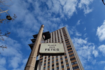 Sticker - Place des Fêtes. Paris.  Plaque de nom de rue sur fond d'immeuble et ciel bleu avec nuages blancs.
