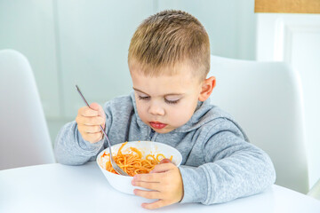 Wall Mural - children in the kitchen at the table turning pasta.