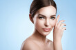 © blackday - Young woman with natural makeup and smooth skin against light blue background
