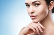 © blackday - Young woman with natural makeup and smooth skin against light blue background