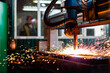 © st.kolesnikov - CNC laser plasma. Selective focus on modern technology laser plasma cutting of metal in process at metalworking factory male worker on background copyspace