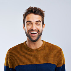 Sticker - Just laugh. Studio shot of a happy and handsome man laughing against a gray background.