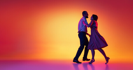 Wall Mural - Portrait of excited man and woman, couple of dancers in vintage retro style outfits dancing lindy hop dance isolated on gradient yellow and purple background. Flyer