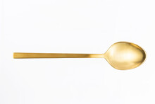 Close-up Of Gold Spoon On White Background