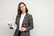 © Martin Villadsen - Beautiful and smiling business woman with paperwork in hands, standing isolated on white, looking happy about the papers she's holding and smiling in to the camera.