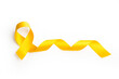 © Mercedes Fittipaldi - Lazo amarillo sobre un fondo blanco liso y aislado. Vista superior y de cerca. Copy space. Concepto: conciencia del cáncer