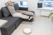 © Angelov - Robotic vacuum cleaner cleaning the room while woman resting