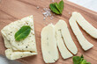Grilled slices of halloumi cheese with grill marks and mint. Cyprus squeaky cheese with mint and almonds on a wooden board. banner, menu, recipe place for text, top view