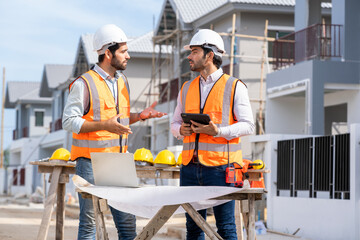 Fototapete - Engineers talking with builders and using laptop and blueprint to discuss about project at construction site,Architecture concept,New house builder.