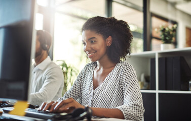 Aufkleber - Shes personally invested in the company. Shot of a young businesswoman working on her computer with her colleague in the background.